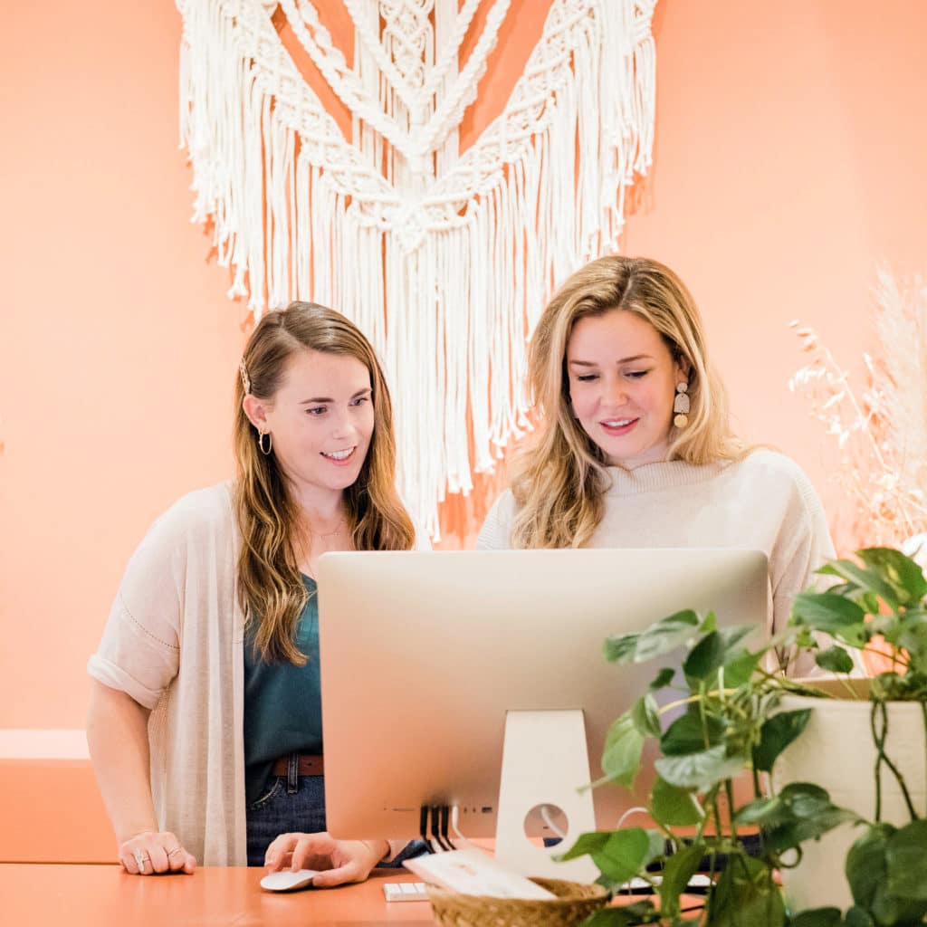 Two women working on their website in front of the computer