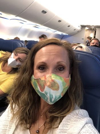 Tami Santini wearing face mask inside the airplane
